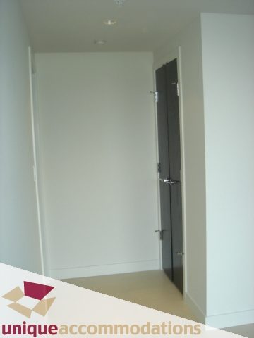Spacious hallway with white walls and dark door, leading to a cozy 2-bedroom condo. - 1101 -1455 Howe Street, Vancouver Downtown