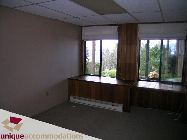 Bright living room with large windows, hardwood floors, and a city view. - 310 Bayview Road, West Vancouver