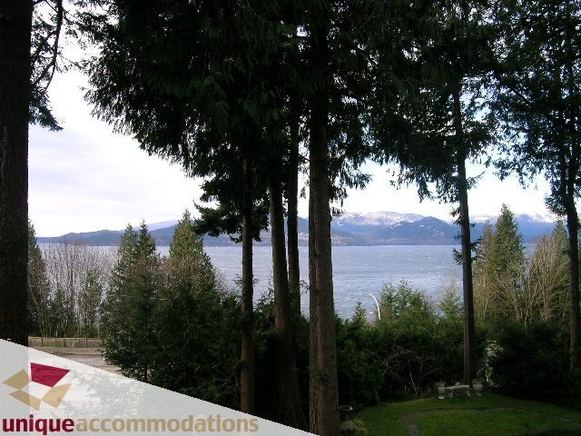 Furnished living room with a view of the mountains and trees. - 310 Bayview Road, West Vancouver