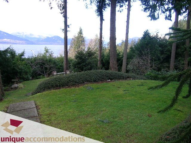 Furnished living room with a view of the lake and forest. - 310 Bayview Road, West Vancouver