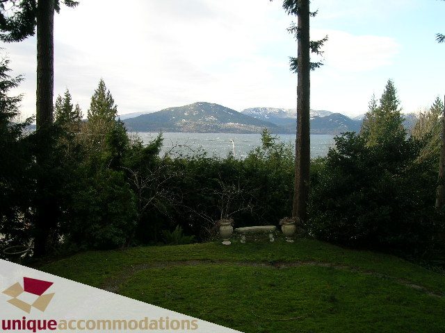 Furnished living room with a stunning view of the lake and mountains. - 310 Bayview Road, West Vancouver