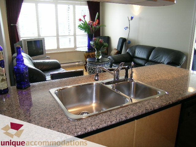 Bright kitchen with granite countertops and stainless steel sink, overlooking cityscape. - 2606-1189 Howe Street, Vancouver Downtown