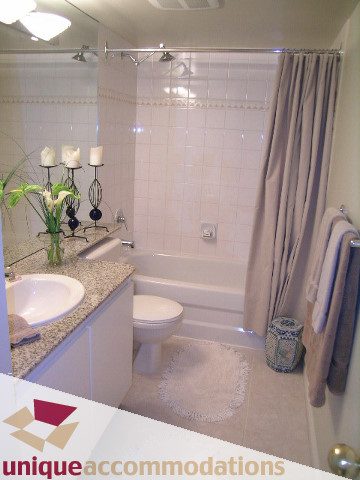 Furnished bathroom with white tiles, shower, and toilet. - 2606-1189 Howe Street, Vancouver Downtown