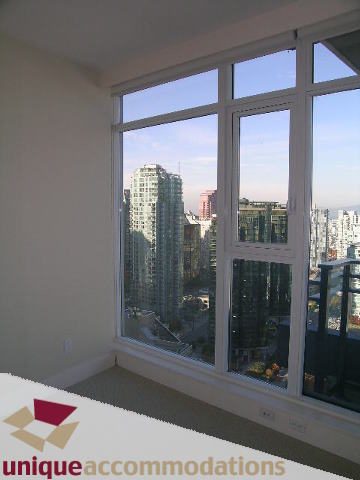 Bright living room with large windows offering a stunning city view. - 2801 - 1205 W. Hastings Street, Vancouver Downtown