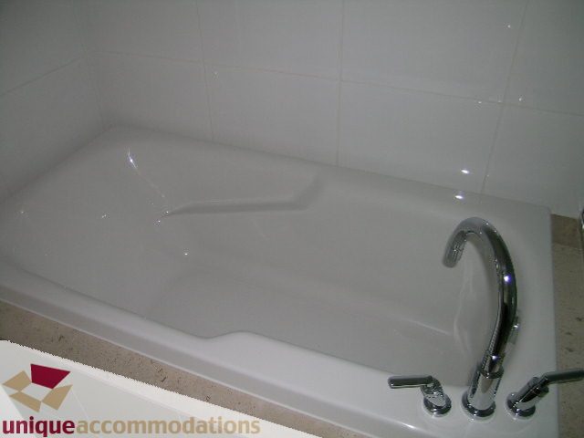 Bathroom with white bathtub, chrome fixtures, and beige countertop. - 2801 - 1205 W. Hastings Street, Vancouver Downtown
