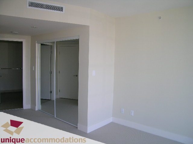 Bright living room with sliding glass doors leading to a balcony, carpeted floor. - 2801 - 1205 W. Hastings Street, Vancouver Downtown