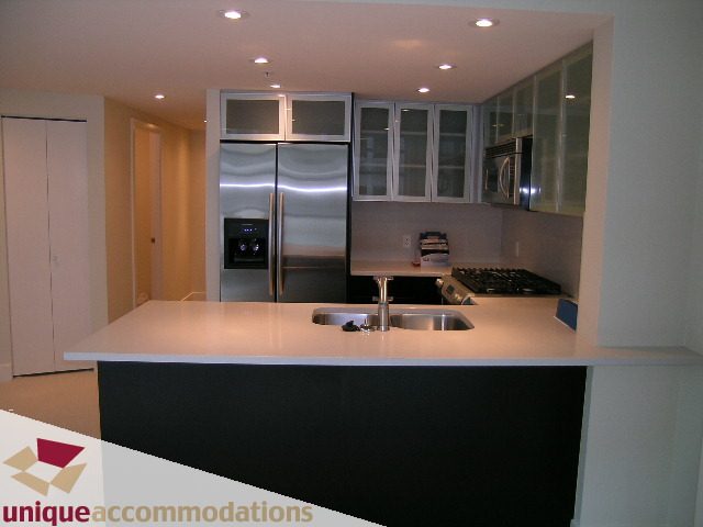 Bright kitchen with white countertops and stainless steel appliances, modern design. - 705 - 1205 W Hastings, Vancouver Downtown