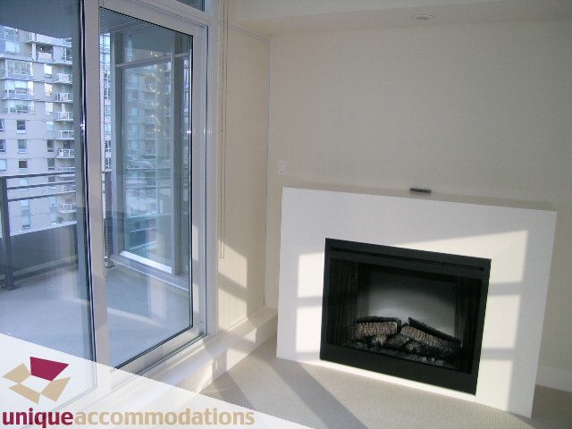 Bright living room with city view and modern fireplace. - 705 - 1205 W Hastings, Vancouver Downtown