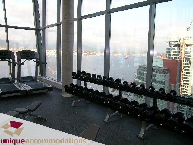 Bright gym with city view and dumbbells, overlooking the harbor. - 705 - 1205 W Hastings, Vancouver Downtown
