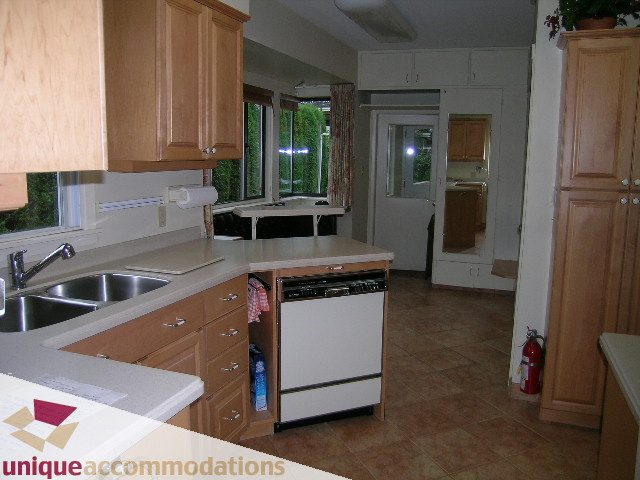 Bright kitchen with light wood cabinets, granite countertops, and a view of the outdoors. - 782 W 22nd Ave, Vancouver West Side