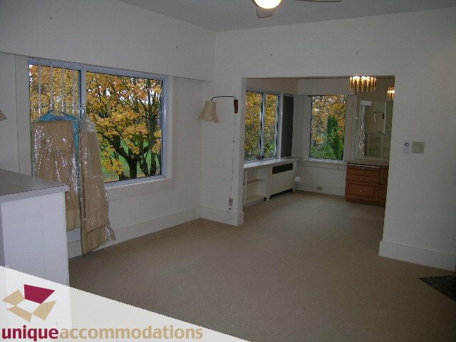 Spacious living room with large windows, hardwood floors, and a view of autumn trees. - 782 W 22nd Ave, Vancouver West Side