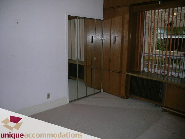 Furnished living room with wooden cabinets and sliding glass doors leading to an outdoor area. - 782 W 22nd Ave, Vancouver West Side