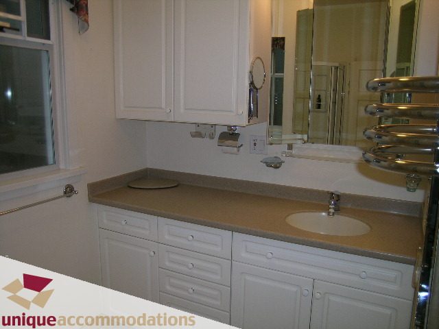 Bright bathroom with white cabinets and beige countertops. - 782 W 22nd Ave, Vancouver West Side