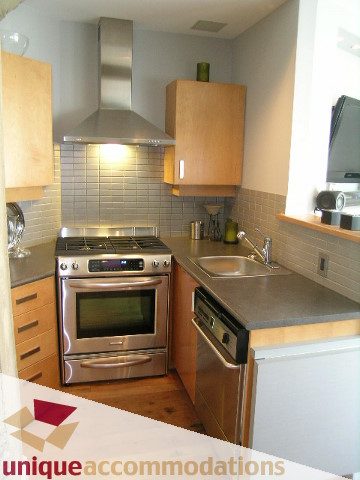 Bright kitchen with stainless steel appliances, wooden cabinets, and hardwood floors. - 211- 1216 Homer, Vancouver Downtown