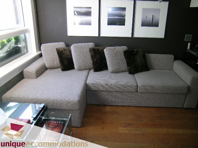 Furnished living room with modern sectional sofa, hardwood floors, and wall art. - 211- 1216 Homer, Vancouver Downtown