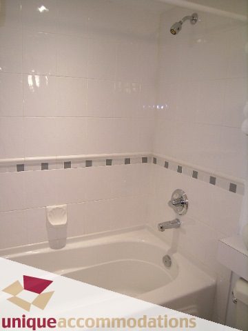 Furnished bathroom with white tiles and a corner tub. - 211- 1216 Homer, Vancouver Downtown