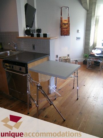 Bright kitchen with modern counter, hardwood floors, and a sleek table setup. - 211- 1216 Homer, Vancouver Downtown