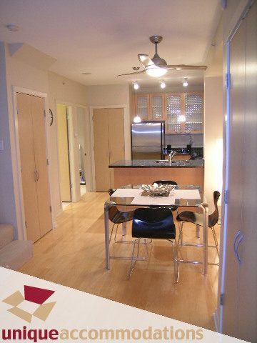 Bright kitchen with stainless steel appliances and wooden cabinets, hardwood floors. - 935 Richards Street, Vancouver Downtown