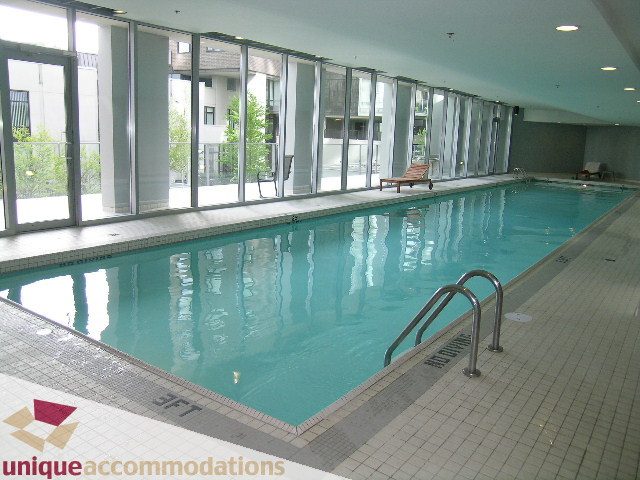 Spacious indoor pool with large windows and lounge chairs. - 3301-1495 Richards, Vancouver Downtown