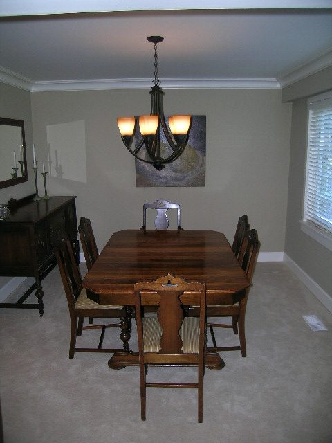 Formal dining room with wooden table, chairs, and chandelier, perfect for entertaining. - 3554 St. Andrews Avenue, North Vancouver