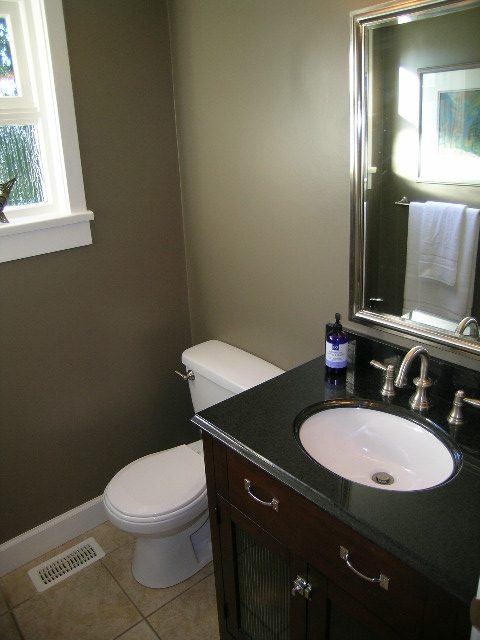 Modern bathroom with dark countertops and a sleek sink, featuring a window with a view. - 3554 St. Andrews Avenue, North Vancouver