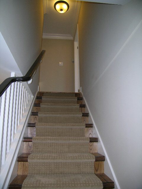 Staircase leading to upper floors with carpeted steps and wooden railings. - 3554 St. Andrews Avenue, North Vancouver