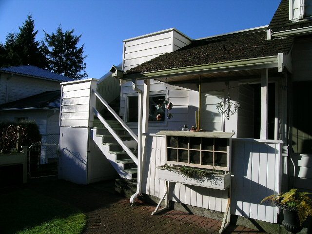 Bright sunlit porch with white siding and hanging plants, perfect for relaxation. - 3554 St. Andrews Avenue, North Vancouver