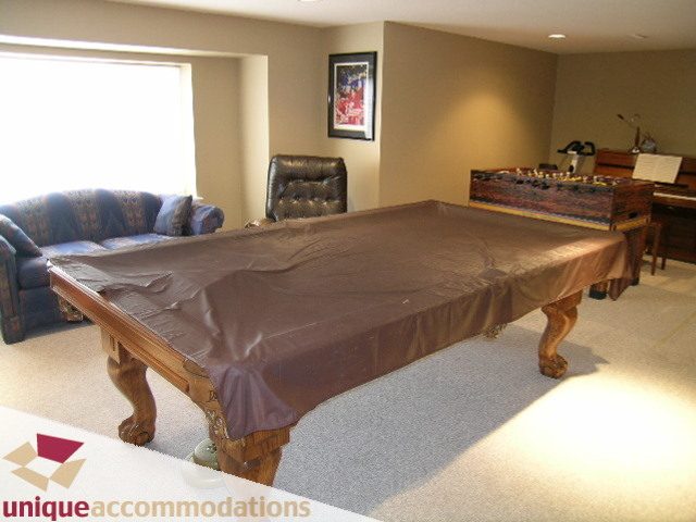 Furnished living room with pool table, leather couch, and piano. - 4139 Quarry Court, North Vancouver