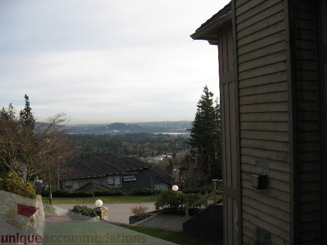 Furnished living room with city view and large windows. - 4139 Quarry Court, North Vancouver