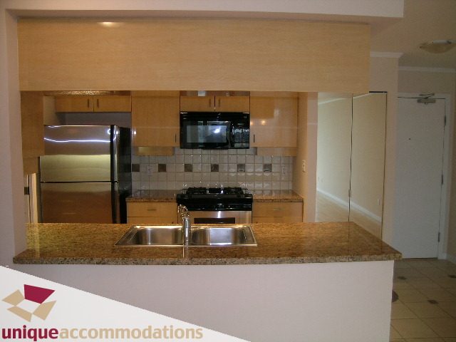 Bright kitchen with granite countertops, stainless steel appliances, and light wood cabinets. - 2908 - 1033 Marinaside Crescent, Vancouver Downtown