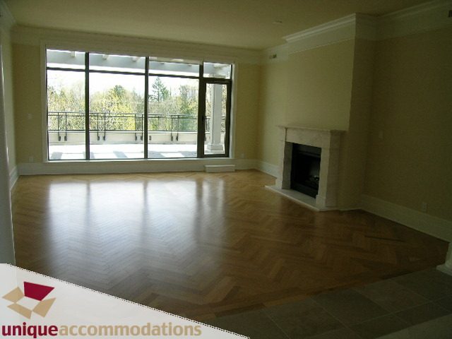 Spacious living room with hardwood floors, large windows, and a fireplace. - PH1 - 508 Waters Edge Cres., West Vancouver