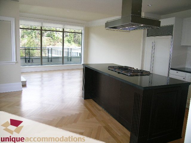 Bright kitchen with dark countertops, hardwood floors, and a city view. - PH1 - 508 Waters Edge Cres., West Vancouver