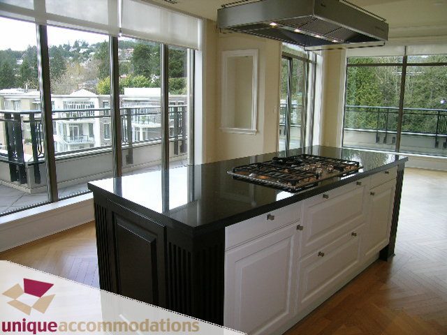 Bright kitchen with black countertops, hardwood floors, and a city view. - PH1 - 508 Waters Edge Cres., West Vancouver