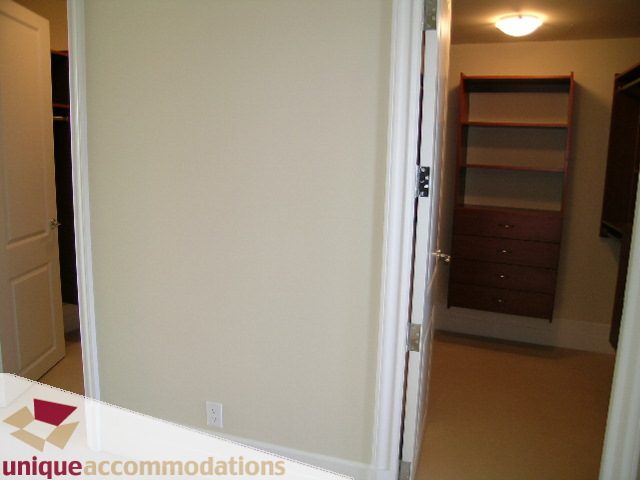 Bright den with white walls, wooden shelves, and a closet. - PH1 - 508 Waters Edge Cres., West Vancouver