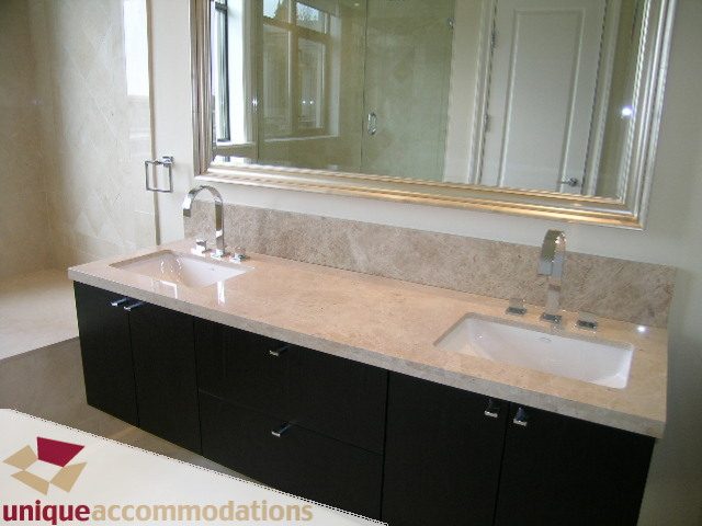 Bathroom with double vanity, granite countertops, and large mirror. - PH1 - 508 Waters Edge Cres., West Vancouver