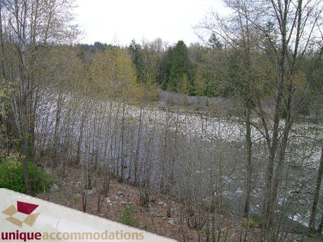 Furnished living room with view of trees and water. - PH1 - 508 Waters Edge Cres., West Vancouver