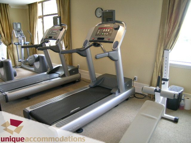 Fitness room with treadmills and exercise equipment, carpeted floor. - PH1 - 508 Waters Edge Cres., West Vancouver