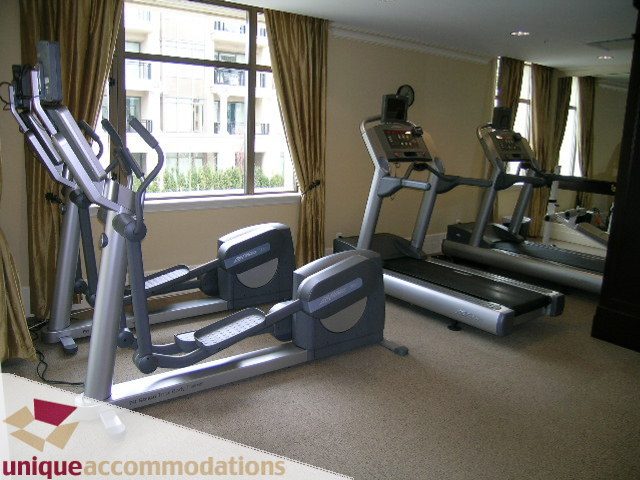 Bright gym with cardio machines and large windows offering city views. - PH1 - 508 Waters Edge Cres., West Vancouver