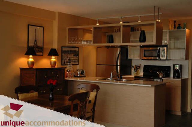 Furnished kitchen with wooden cabinets, granite countertops, and city view. - 2314 - 938 Smithe Street, Vancouver Downtown