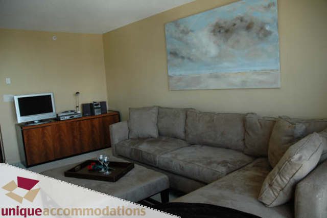 Furnished living room with a cozy sofa and a flat-screen TV. - 2314 - 938 Smithe Street, Vancouver Downtown