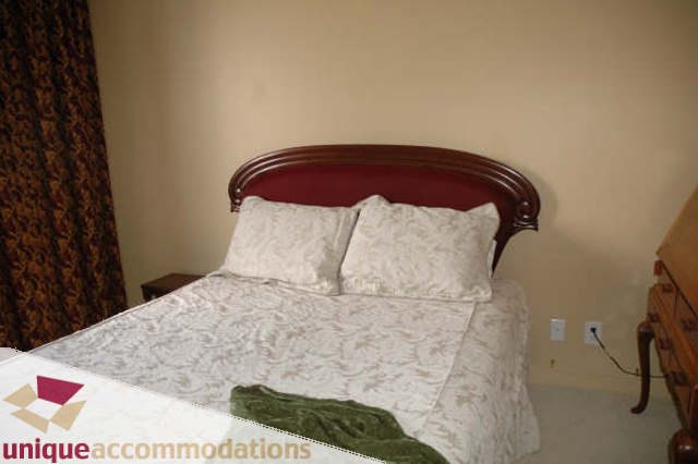 Furnished 2-bedroom + den with elegant bedding and a classic wooden headboard. - 2314 - 938 Smithe Street, Vancouver Downtown