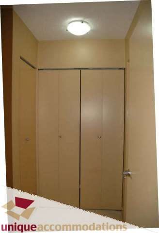 Furnished bedroom with wooden closet doors and a ceiling light. - 2314 - 938 Smithe Street, Vancouver Downtown