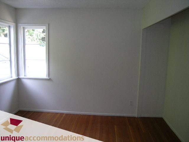 Bright living room with hardwood floors and large windows. - 1428 29th Street, West Vancouver
