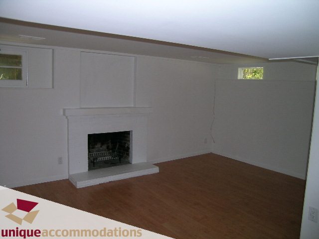 Living room with hardwood floors and a modern fireplace. - 1428 29th Street, West Vancouver