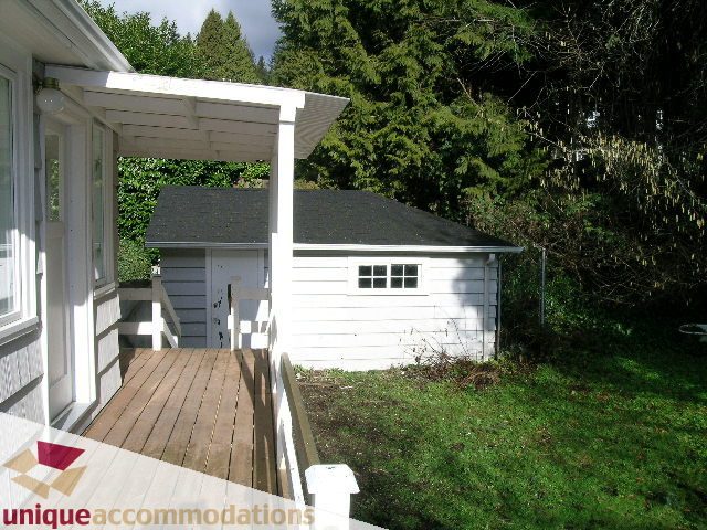 Furnished patio with wooden deck and lush greenery. - 1428 29th Street, West Vancouver