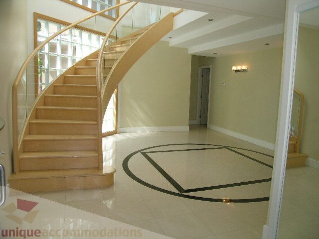 Staircase with glass railings and tiled floor leading to upper level. - 4215 Evergreen Ave, West Vancouver