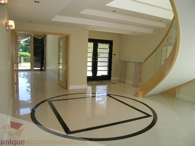 Spacious foyer with circular marble floor design and glass railing. - 4215 Evergreen Ave, West Vancouver