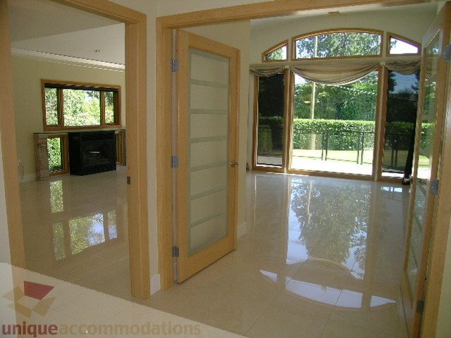 Bright living room with glossy tiled floors and a view of the garden outside. - 4215 Evergreen Ave, West Vancouver