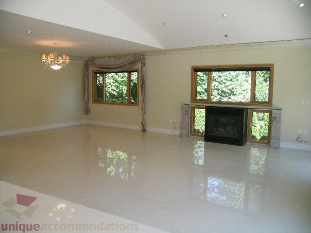 Spacious living room with glossy floors and large windows. - 4215 Evergreen Ave, West Vancouver