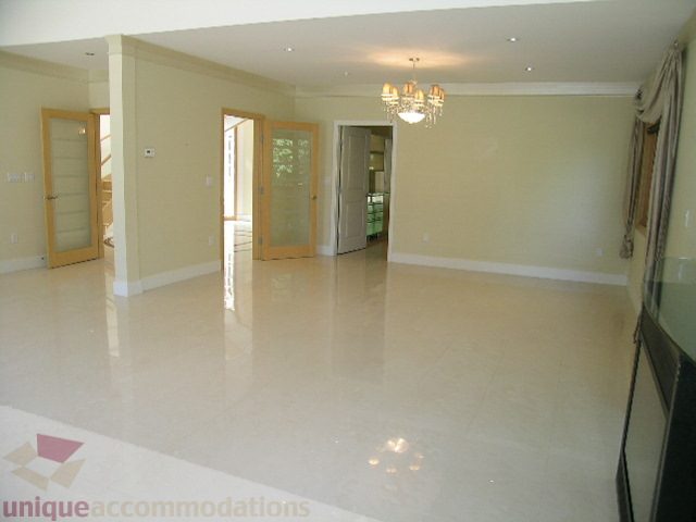 Spacious living room with glossy floors and chandelier. - 4215 Evergreen Ave, West Vancouver